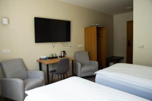 a hotel room with two beds and a tv on the wall at Hótel Búrfell in Vík