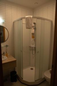 a shower in a bathroom with a sink and a toilet at Hótel Búrfell in Vík +49 photos