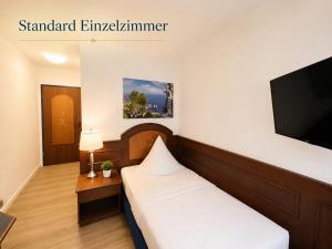 a hotel room with a bed and a flat screen tv at Hotel Garni Italia in Bühl