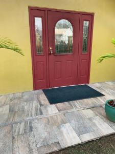 a red door on a yellow house with a mat in front at Alluring Ambrosia in Arouca