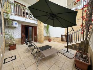 a patio with a chair and an umbrella at Apartment Simone in Lecce