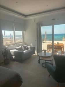a living room with a couch and a view of the beach at Socrates Seaside Apartments in Milatos
