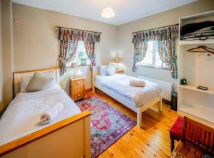 a bedroom with two beds and a rug at Knockaderry House in Ennis