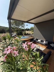 a patio with pink flowers and a large umbrella at Aurea Beach House in Tisno