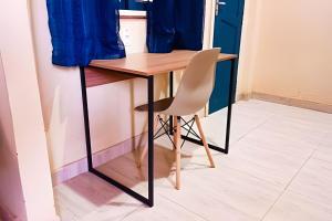 a desk with a chair and a blue curtain at Casa Marajoara in Soure