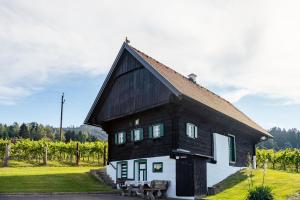a black and white building in a field of grapes at Winzerhaus Löscherannerl in Kogl