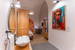 a bathroom with a sink and a painting on the wall at DAR MEMOIR Apart Hotel in Al Mudawwar +149 photos