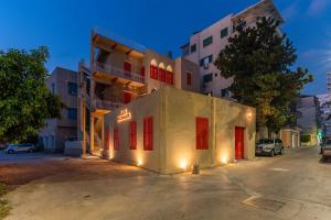 a building with red doors in front of a building at DAR MEMOIR Apart Hotel in Al Mudawwar