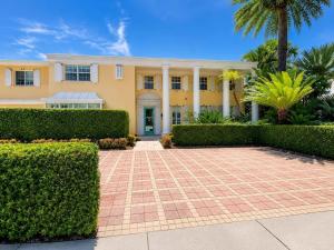 a yellow house with a palm tree and bushes at Monaco Bay Club 10 in Fort Lauderdale