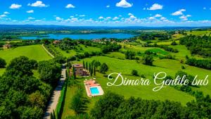an aerial view of a house in a field with a lake at Dimora Gentile BnB in Castiglione del Lago