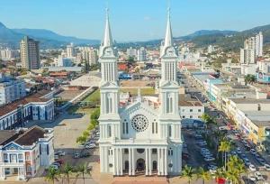 a large white church with two towers in a city at Eduardos Hotel in Rio do Sul