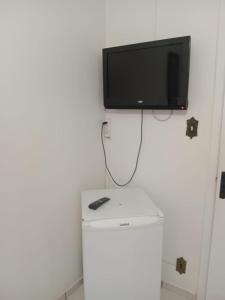 a television on top of a refrigerator in a room at Eduardos Hotel in Rio do Sul +8 photos