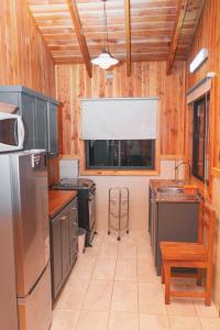 a kitchen with wooden walls and a large window at Cabañas en neltume in Neltume