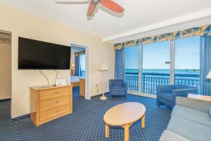 a living room with a television and a couch and a table at Oceanfront 1BR by Skywheel Yachtsman 701 in Myrtle Beach +60 photos