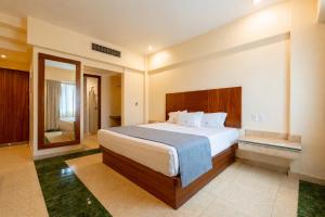 a bedroom with a large bed and a bathroom at Hotel Real Del Sol in Guadalajara