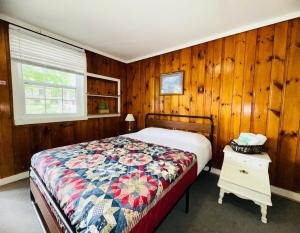 a bedroom with a bed and a wooden wall at Rock Castle Resort in Lake George
