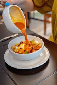 a bowl of soup on a table with a cup of sauce at Hotel Real Del Sol in Guadalajara