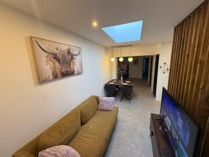a living room with a couch and a flat screen tv at Capstay - Charleroi in Charleroi