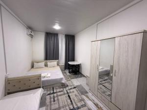 a small room with two beds and a mirror at 888 отель in Yunusobod