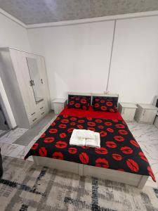 a bedroom with a bed with a red rose bedspread at 888 отель in Yunusobod