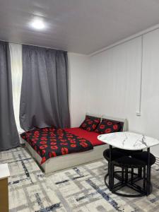 a small bedroom with a bed and a table at 888 отель in Yunusobod