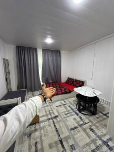 a person pointing at a couch in a room at 888 отель in Yunusobod