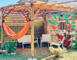 a wooden pergola with a hammock under it at La Maison Le 14 - Un Jardin en Ville in Auxerre