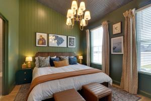 a bedroom with green walls and a bed and a chandelier at Dock Access! 'Hook & Heron Lakefront Getaway' in Greenwood