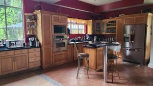 a large kitchen with wooden cabinets and stainless steel appliances at Casa Vista in Loango