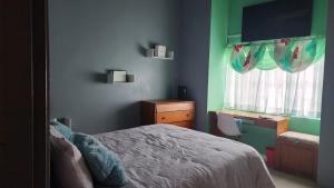 a bedroom with a bed and a desk and a window at Casa Vista in Loango
