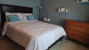 a bedroom with a bed and a wooden dresser at Casa Vista in Loango +16 photos