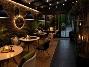 a restaurant with tables and chairs and lights at Vila GARUFA Wellness & Spa in Vysoké Tatry