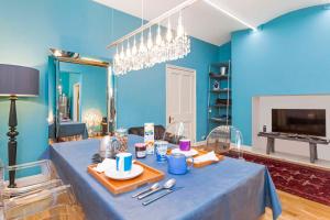 ein blaues Zimmer mit einem Tisch mit Tellern und Küchenutensilien in der Unterkunft South Kensington Apartment x4 in London