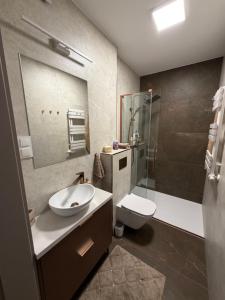 a bathroom with a sink and a toilet and a shower at Apartament Kaszmirowy in Nysa +8 photos