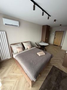 a bedroom with a bed and a table in it at Apartament Kaszmirowy in Nysa