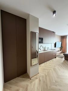 a kitchen with wooden floors and brown cabinets at Apartament Kaszmirowy in Nysa