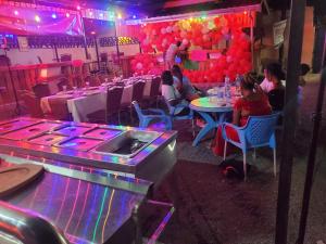 a group of people sitting at tables in a room with balloons at Torchys in Kisumu