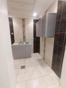 a bathroom with a sink and a tiled floor at غرف عزاب وشقق عوايل in Riyadh