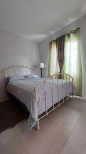 a bedroom with a bed and two windows at Santa Fe in Port-of-Spain