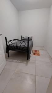 a black bench in a white room with a tile floor at Santa Fe in Port-of-Spain