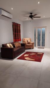 a living room with a couch and two chairs at Santa Fe in Port-of-Spain