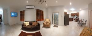 a living room with a couch and chairs and a kitchen at Santa Fe in Port-of-Spain +10 photos