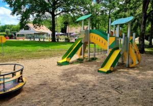 a playground with a slide in a park at Terracotta Lodge - Un cocon chaleureux pour des vacances inoubliables in Nibelle