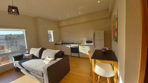 a living room with a couch and a kitchen at Brisas Apart in Olavarría +3 photos