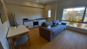 a living room with a couch and a kitchen at Brisas Apart in Olavarría