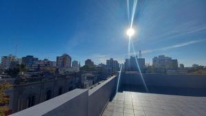 a view of a city with the sun shining on a building at Brisas Apart in Olavarría