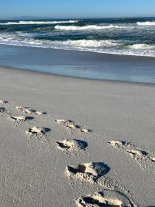 a pair of footprints in the sand on the beach at Duneberry Beach Studio in Yzerfontein