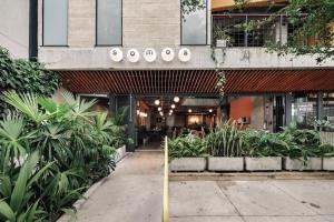 The Somos S Hotel في ميديلين: مبنى به مجموعة من النباتات أمامه