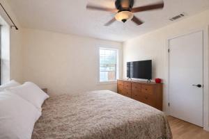 a bedroom with a bed and a ceiling fan at Live Oak Home with Garden Studio in Gainesville