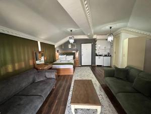 a living room with a couch and a bed at Riwaner Hotel in Avcılar